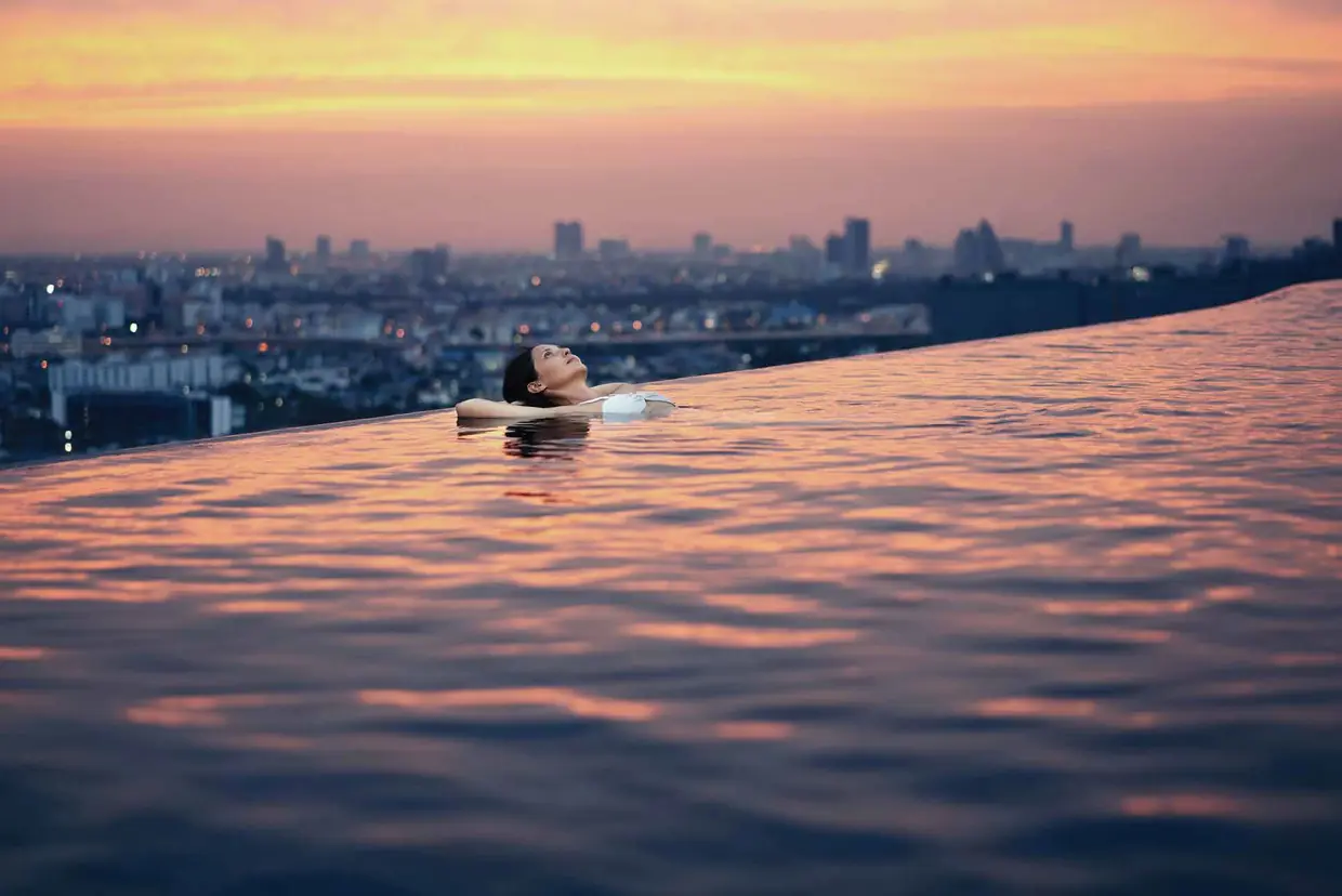 Rooftop infinity pool overlooking the city at dusk
