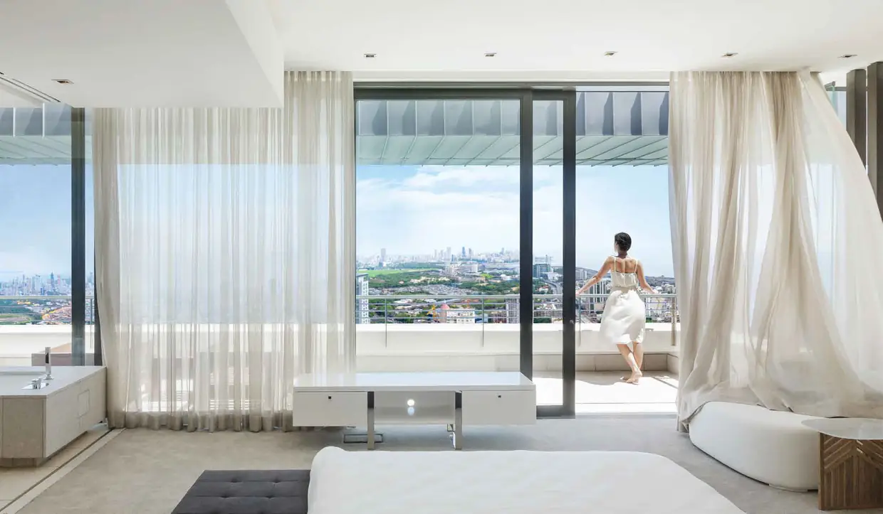 Luxury bedroom opening to a panoramic city and sea view